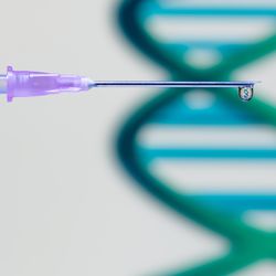 syringe needle with droplet of vaccine containing tiny DNA molecule, with large green DNA molecule out of focus in the background