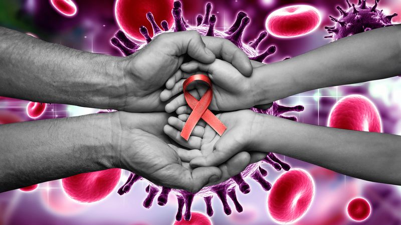 hands holding red HIV awareness ribbon against a backdrop showing retrovirus particles and blood cells