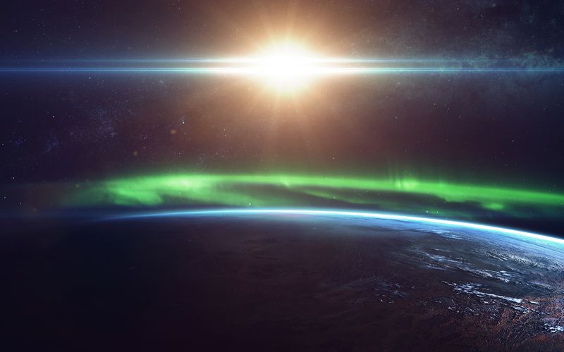 Artist impression of the northern lights from space over the limb of our planet with the Sun behind