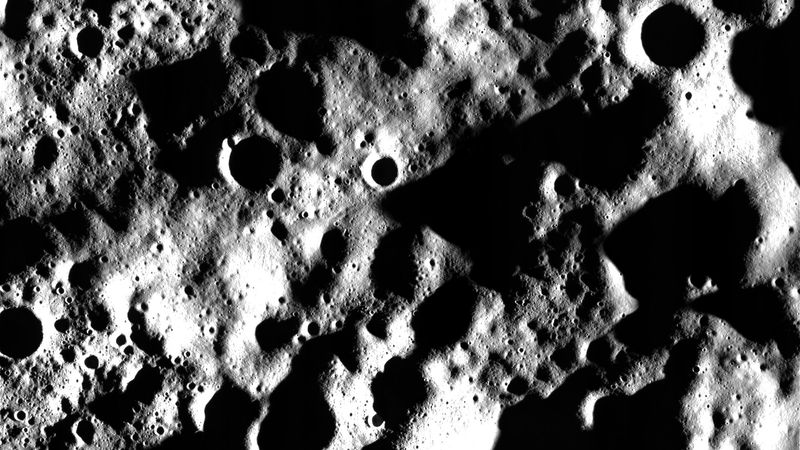 An heavily cratered area of the Moon with many of the craters in darkness but for the rim are visible in this photo