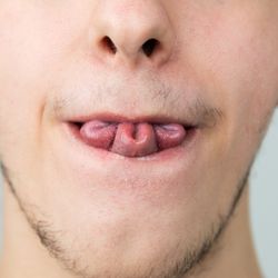 Person rolling their tongue, into a clover leaf.