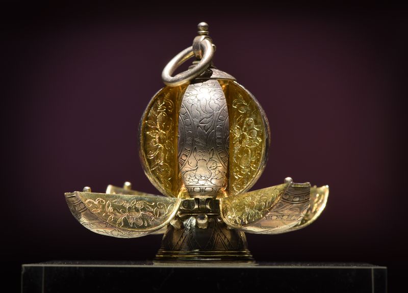 A silver round pomander with eight compartments that would each contain a fragrant spice.