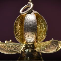 A silver round pomander with eight compartments that would each contain a fragrant spice.