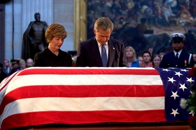 President George W. Bush and Laura Bush pay their final respects at the casket containing the body of former President Ronald Reagan in the U.S. Capitol Rotunda on June 10, 2004.