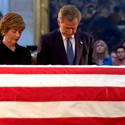 President George W. Bush and Laura Bush pay their final respects at the casket containing the body of former President Ronald Reagan in the U.S. Capitol Rotunda on June 10, 2004.