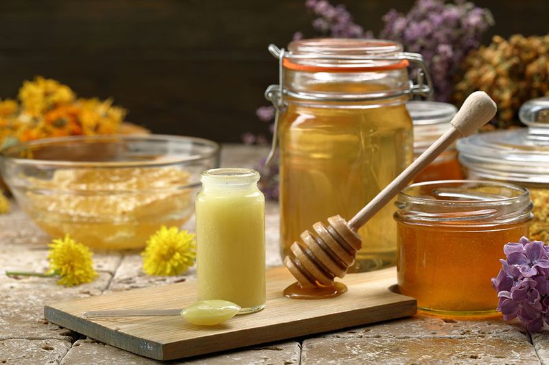 Jars of royal jelly and honey on a table