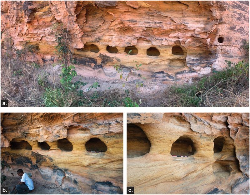 Three photos showing the smaller stone niches carved into the cliff face. The top image shows the niches in the red sandstone from further back. There are grasses in the foreground. The photo on the bottom left shows a close up of the niches to the left of the row. A man is visible in the bottom left corner as he is excavating. The photo on the bottom right shows the remaining three niches on the right of the row. 