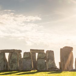 An image of Stonehenge in full sunshine. The circle of stones os clearly visible