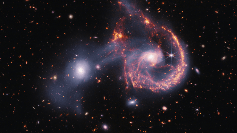 The image shows a large spiral galaxy whose main spiral arm is almost a semi circle, no other arms are present but wips of gas are extended around it, evidence of the merger. Next to it the elliptical galaxy mostly unaltered bu white gas extends from it to the spiral as well as creating a cone in the opposite direction.