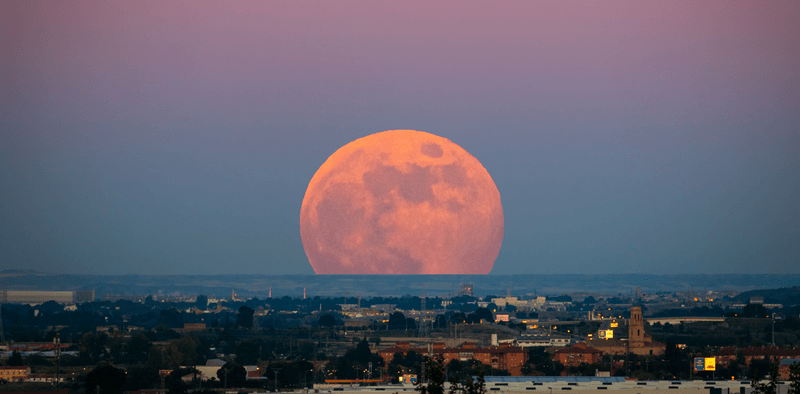 The moon looking particularly large (and red) against the backdrop of a Spanish city in June 2020. 