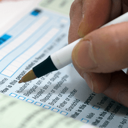 A hand holding a pen fills out the US Census in 2010.