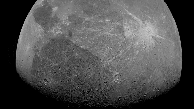 A partial view of ganymede. a few small craters are visible as well as many furrows, the concentric stripes that indicate a massive impact in its past.