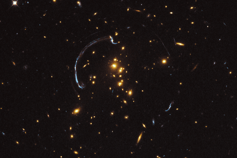 The strength of gravitational lenses like this one in Galaxy Cluster RCS2 032727-132623 are one of the things that make physicists confident dark matter exists, but could also be explained by a new theory.