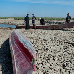 Boats on dried cracked earth during a drought in the Southern Marshes of Iraq