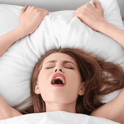 A woman in bed, either snoring really badly or having an orgasm.