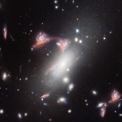 Two distant, interacting galaxies — a face-on spiral and a dusty red galaxy seen from the side — appear multiple times, tracing a question mark on the sky. The main body of the character is create with a bright white boxy galaxy